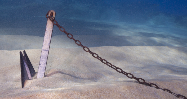 Anker, der im Sand auf dem Meeresboden festsitzt